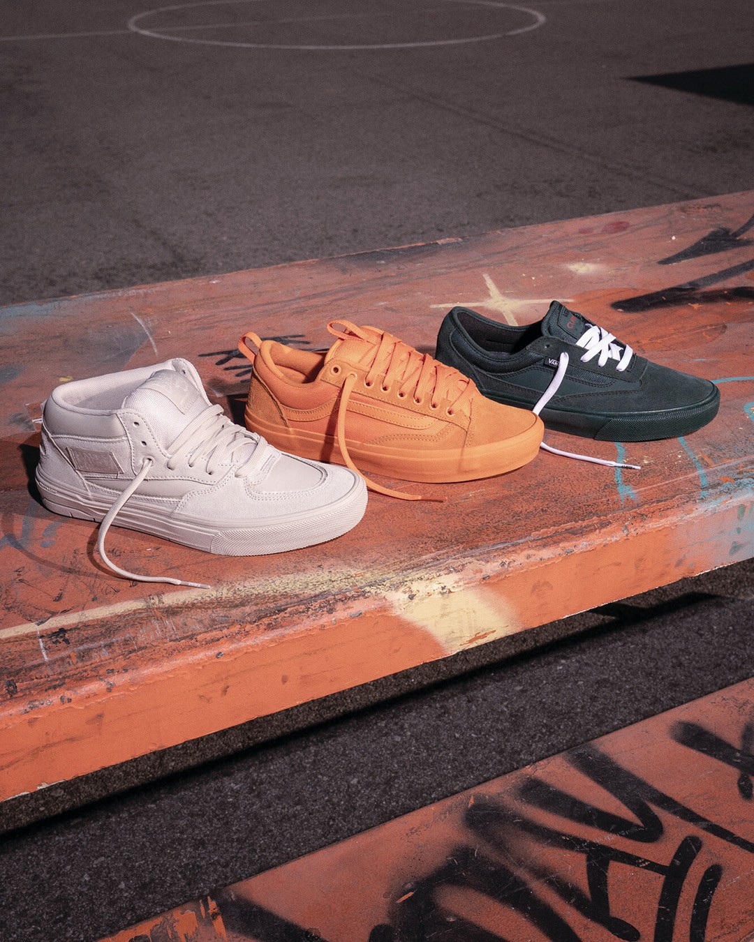 White Half Cab, orange Old Skool 36+ and black Curren Atiba shoe placed on a table.