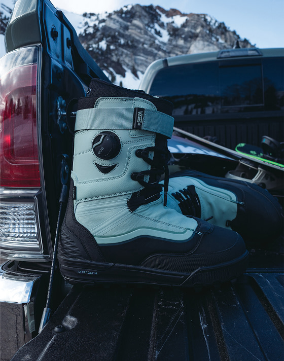 A close-up of the Infuse snowboard boot in the bed of a pickup truck with a snowy mountain in the background.