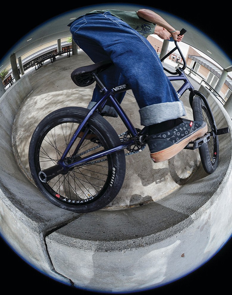 A fisheye shot of someone riding a BMX bike on a wall wearing the black BMX Proof WaffleCup.
