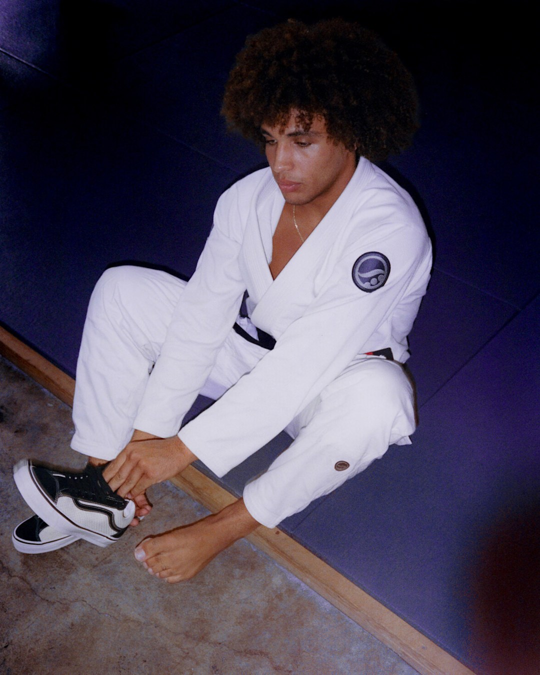 Shoyoroll sitting on BJJ matt changing his shoes.