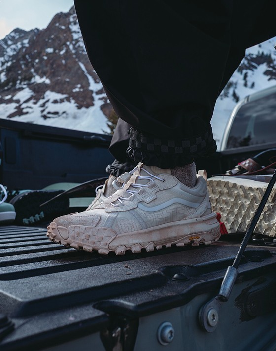 Close-up on the white Crosspath XC GORE-TEX in the bed of a truck with snowboarding gear and a mountain in the background.
