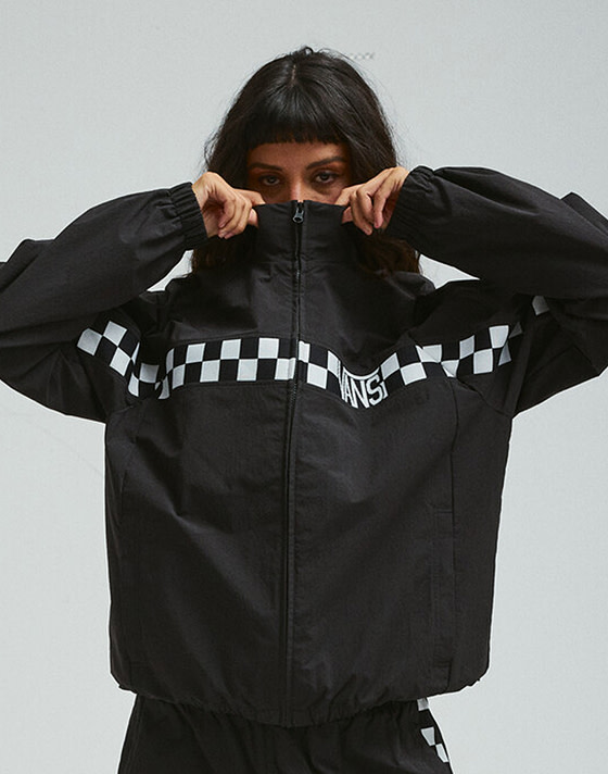 A woman wearing a black and white Checkerboard jacket in a photography studio.