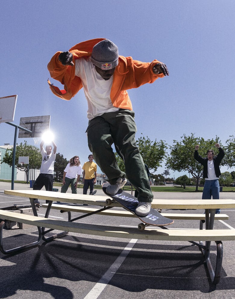 Vans Skate Team Rider Zion Wright grinds on a bench near skaters and celebrities for Atiba Jefferson’s United Through Skateboarding collection.