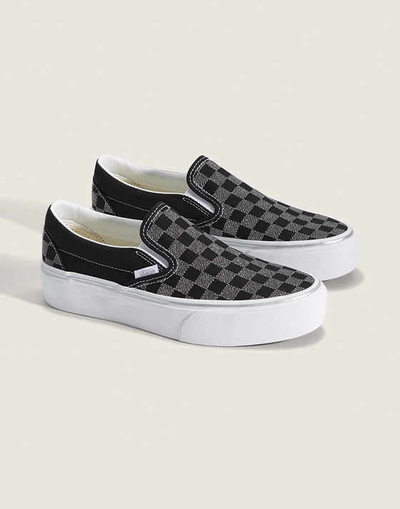 A pair of black and silver Checkerboard Classic Slip-On in a photography studio.