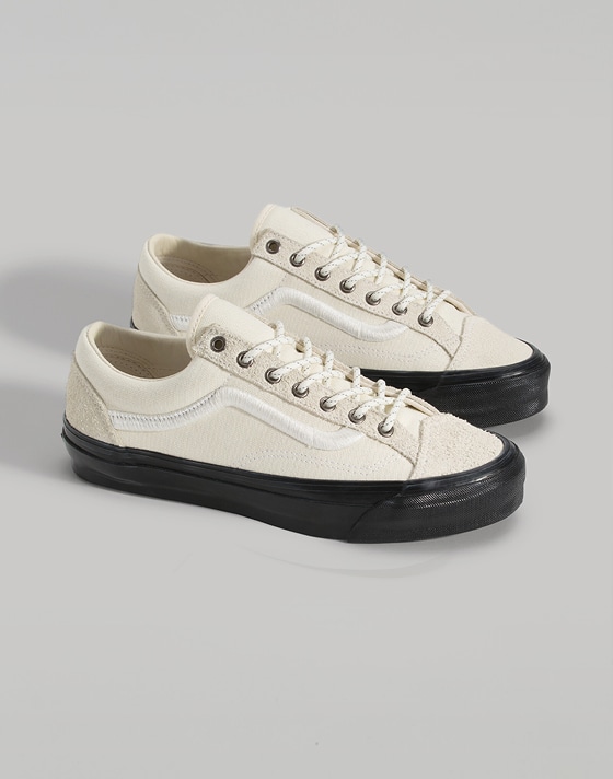 A pair of white on cream Premium Old Skool in a photography studio.