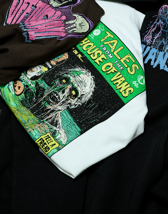 A pile of Halloween tees and their vibrant graphics stacked on top of each other.