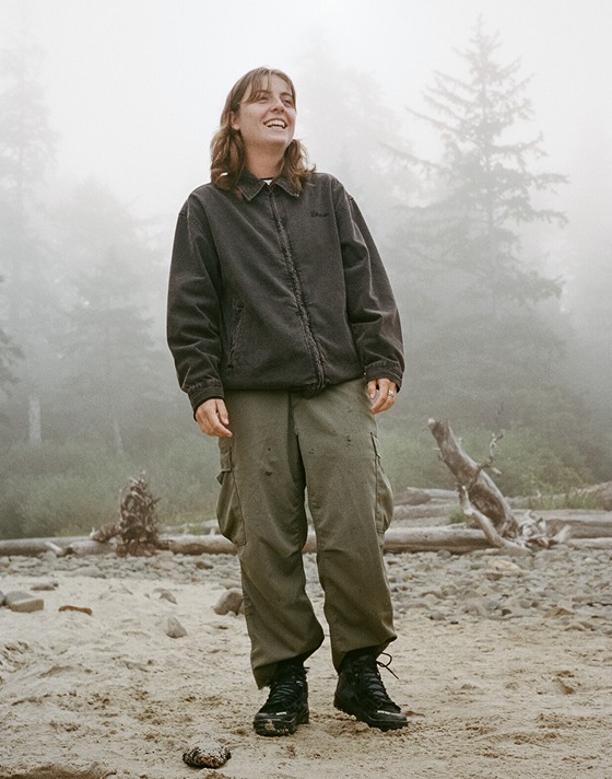 A woman smiles wearing black Sk8-Hi GORE-TEX boots outside.