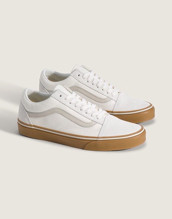 A pair of white Old Skool with gum soles in a photography studio.