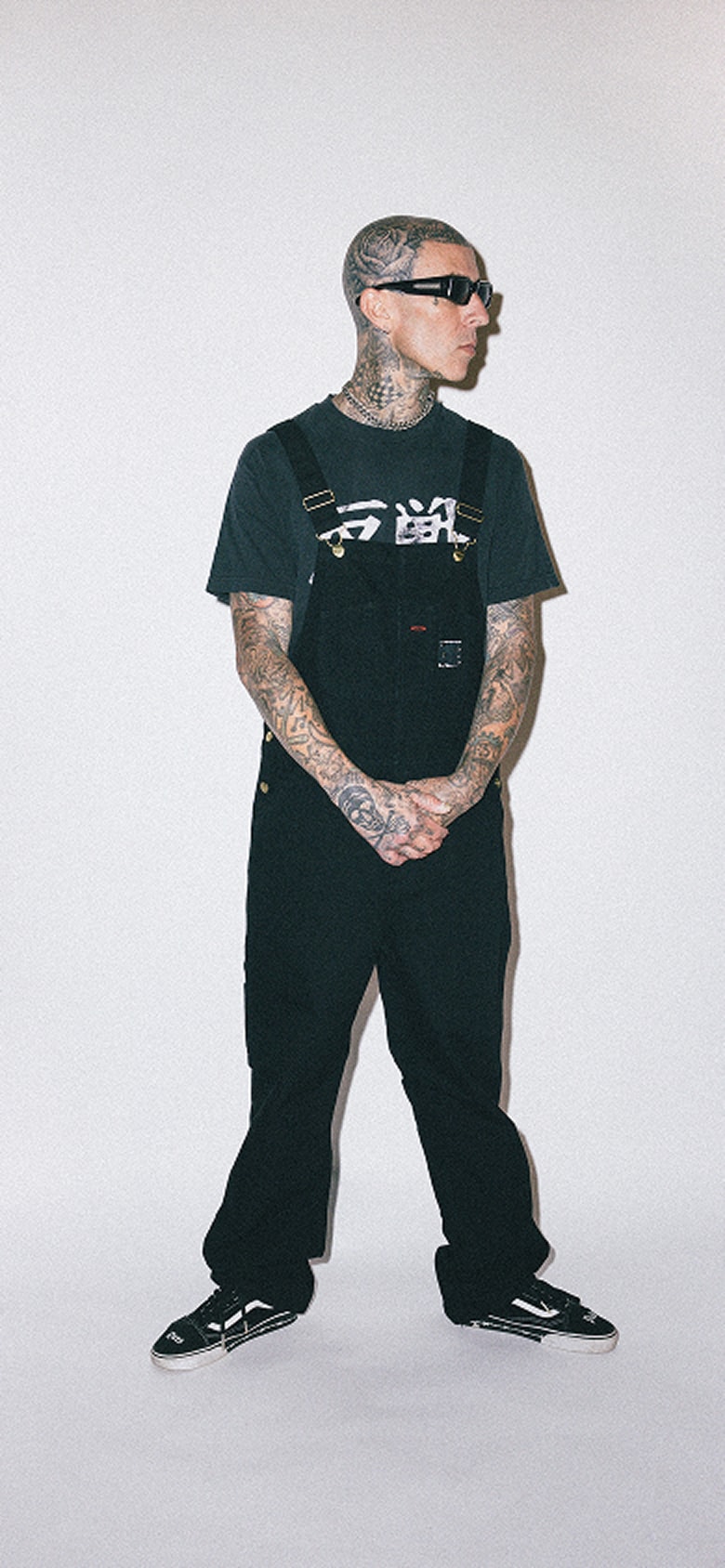 A waist-down shot of Travis Barker wearing the Vans x Travis Barker Old Skool with the Dues Paid emblem.
