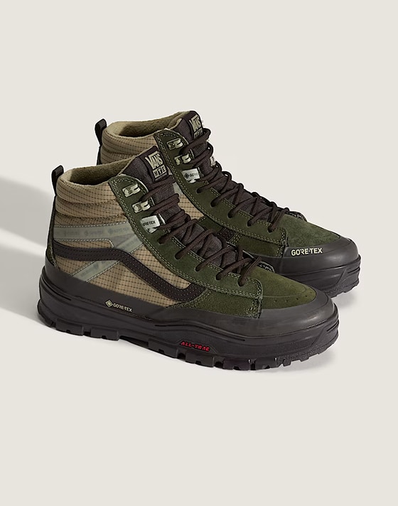 A pair of green and tan Sk8-Hi GORE-TEX in a photography studio.