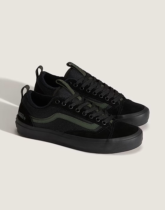 A pair of black Old Skool in a photography studio.