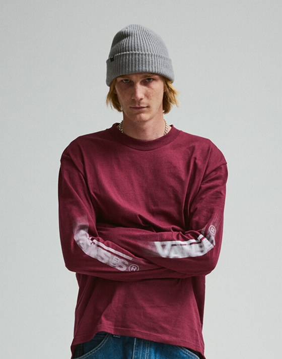 A young man looks into the camera wearing a red Blur Drop Long Sleeve T-Shirt.