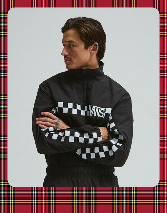 A photograph surrounded by a plaid holiday border of a young man wearing the black Ronnie Track Jacket.