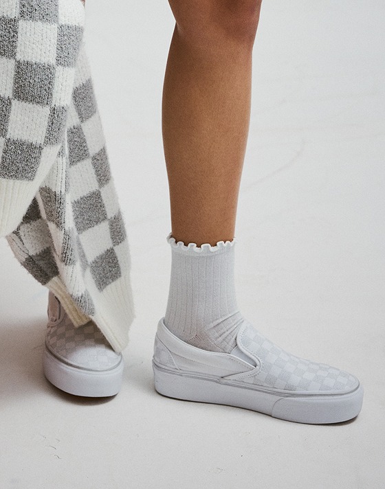 Close-up of the white and gray Classic Slip-On Platform Checkerboard with white frill socks.