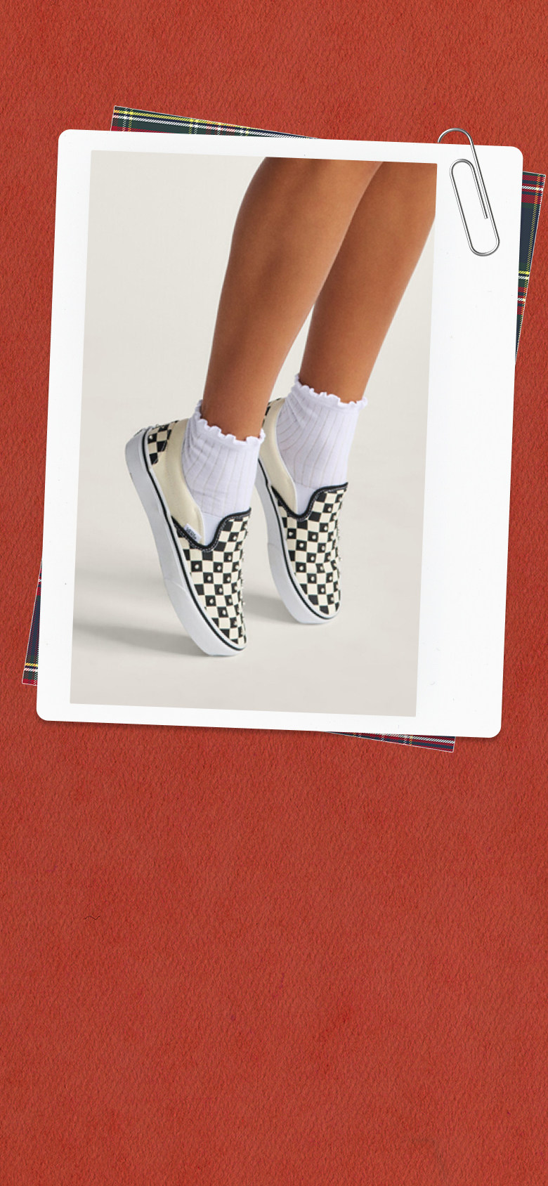 A film photograph of a young woman pulling a Vans hoodie over her face surrounded by a red holiday and a paper clip.