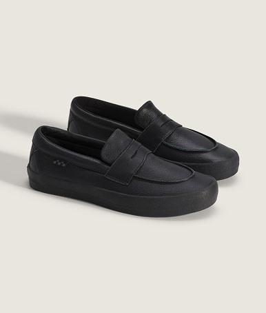 A pair of black Skate Loafers in a photography studio.