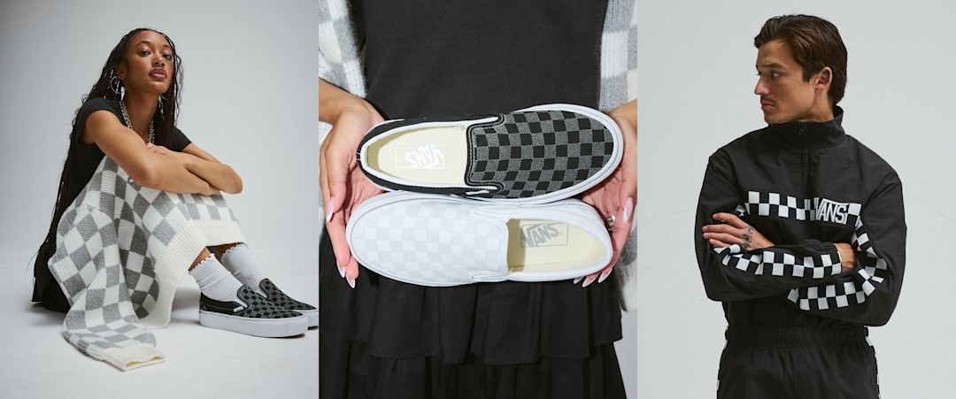 A young woman poses with her arms crossed wearing the Evelyn Cardigan Sweater in a photography studio.