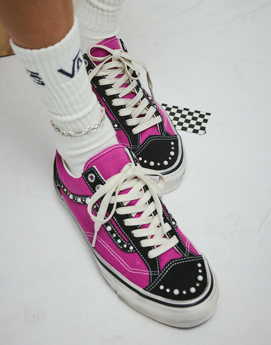 An overhead shot of someone wearing black and magenta Premium Old Skool 36 Pearlized shoes with white Vans crew socks.