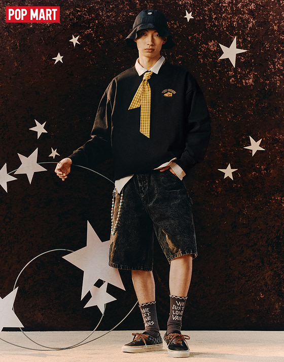 A young man poses demurely wearing the adults’ Vans x Space Molly Authentic with brown socks and black shorts on the set of a space-themed shoot.