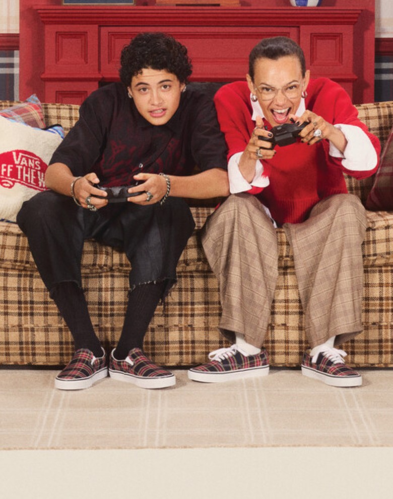 Vans Skate Team Rider Junior Gutierrez and influencer Marz Lovejoy sit on a sofa playing video games wearing plaid Classic Slip-On and Authentic.