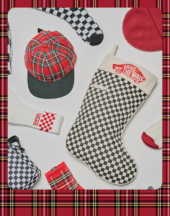 A photograph surrounded by a red plaid holiday border of an Off the Wall Checkerboard stocking, a plaid hat, a red beanie, and various Vans socks.