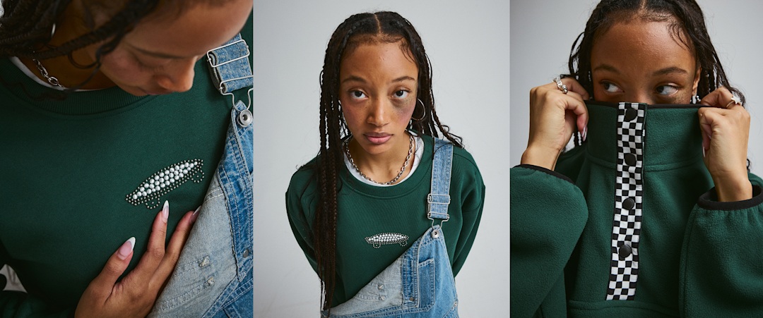 A young woman looks into the camera wearing the Emerald Crew Salton Pearls paired with Sirelle Overalls in a photography studio.
