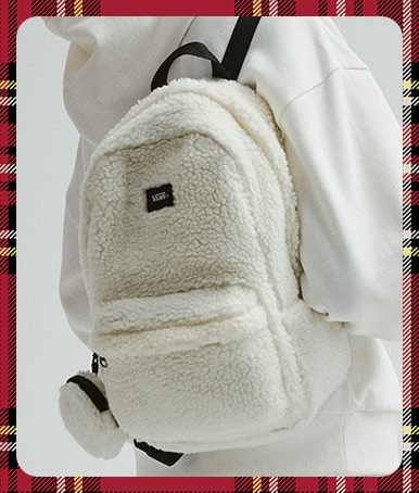 A plaid holiday border around an image of a young woman with a marshmallow white Old Skool Mini Backpack and white Vans clothes.