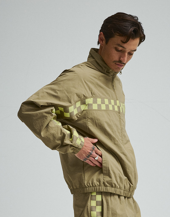 Man wearing Ronnie Track Jacket and Ronnie Track Pants in a photography studio with a grey background.