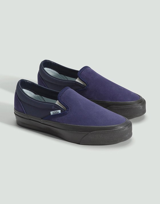 A pair of deep twilight blue Premium Classic Slip-On on the floor of a photography studio.