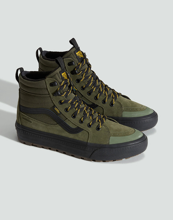 A pair of green and black Sk8-Hi Waterproof Insulated on the floor of a photography studio.