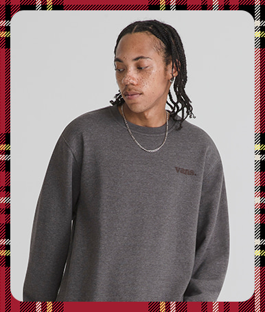 Holiday border with a man in a grey photography studio wearing Vans 66 Crew Sweatshirt in Asphalt Grey