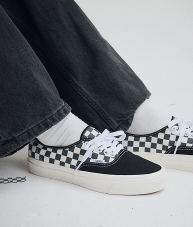 Close up of a man wearing a pair of the Premium Authentic Checkerboard Shoe in Asphalt Grey.
