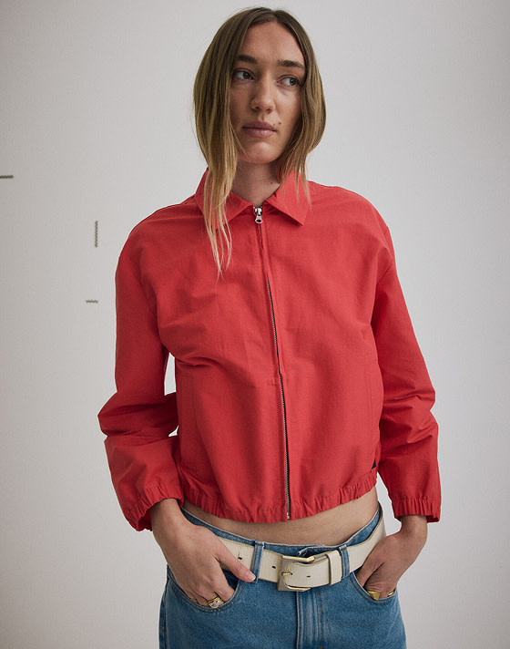 Medium shot of a woman wearing a zipped up Lightweight Bomber Jacket in Racing Red.