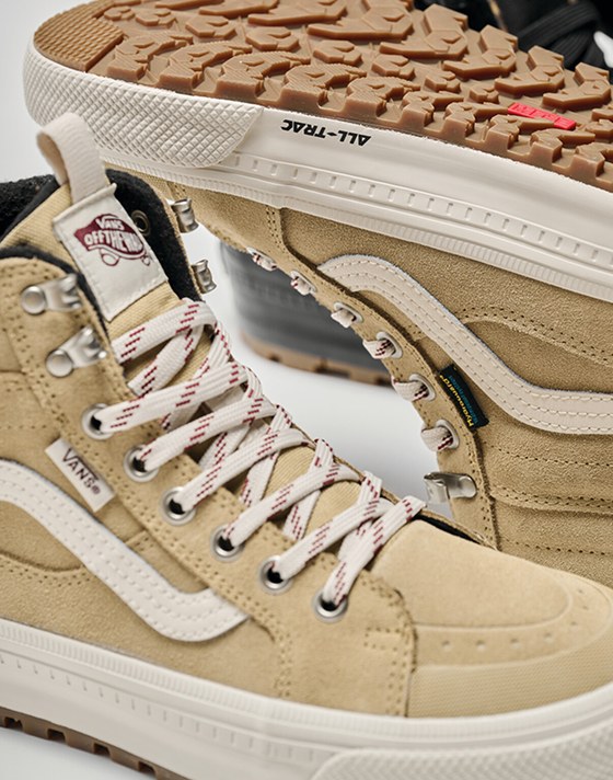 Image of the Sk8-Hi Waterproof Insulated Shoe in Brown / White. One is upright while the other is upside down showing off the All-Trac tread.