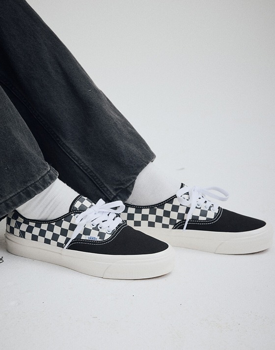 Wide shot of someone wearing a pair of the Premium Authentic Checkerboard Shoe in Checkerboard Asphalt Grey / White.