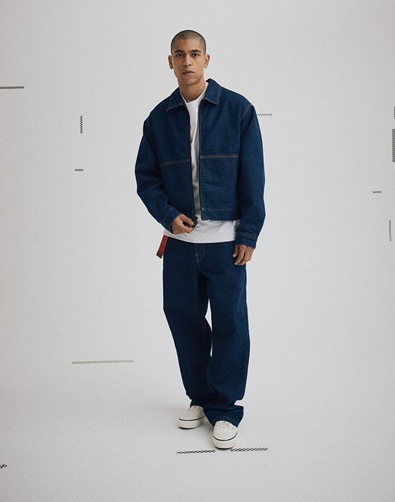 Wide shot of a man wearing the Premium Denim Station Jacket with Premium Check-5 Loose Denim Pants that match.