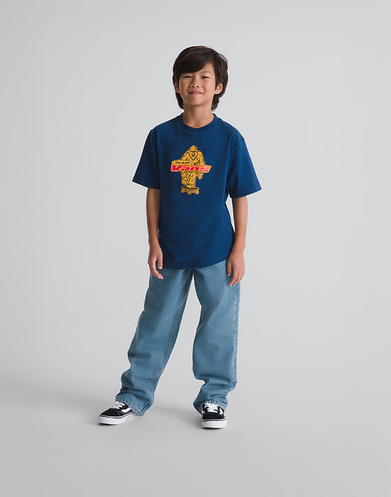 Wide shot of kid wearing a Kids Big Push T-Shirt in Deep Indigo Blue in a grey photography studio.