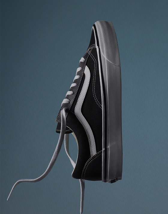 Close up of a single OTW Old Skool 36 in Grey upright in the air with a grey/blue colored background.