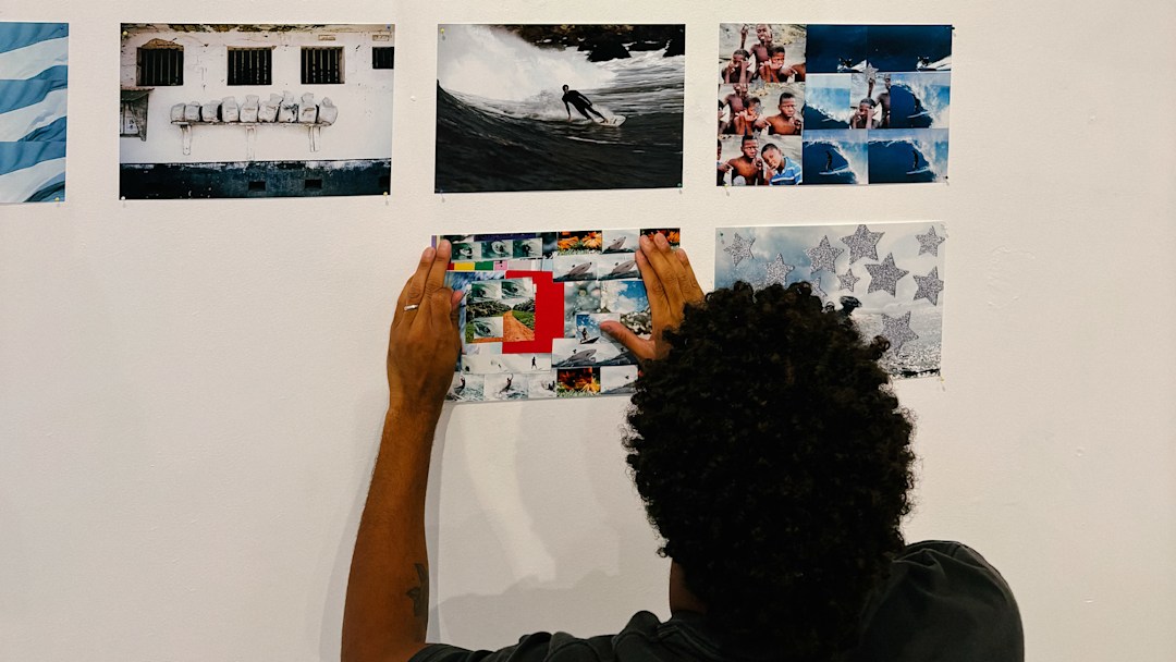 Mikey February placing photos from his book African Space Program on the wall of the Marshall Brothers surf shop.