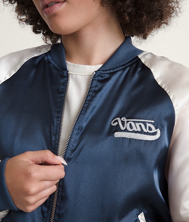 Close-up on a woman zipping up her Souvenir Jacket in a photography studio.
