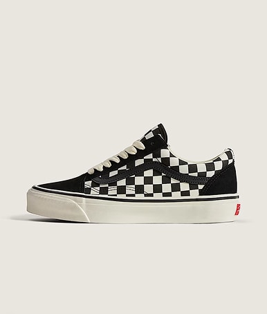 Medium shot of the Premium Old Skool Checkerboard Shoe in black and white with a plain background in a photography studio.