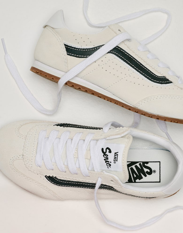 Close up overhead shot of the Big Kids Super Lowpro Shoe in Marshmallow White on the floor of a grey photography studio.