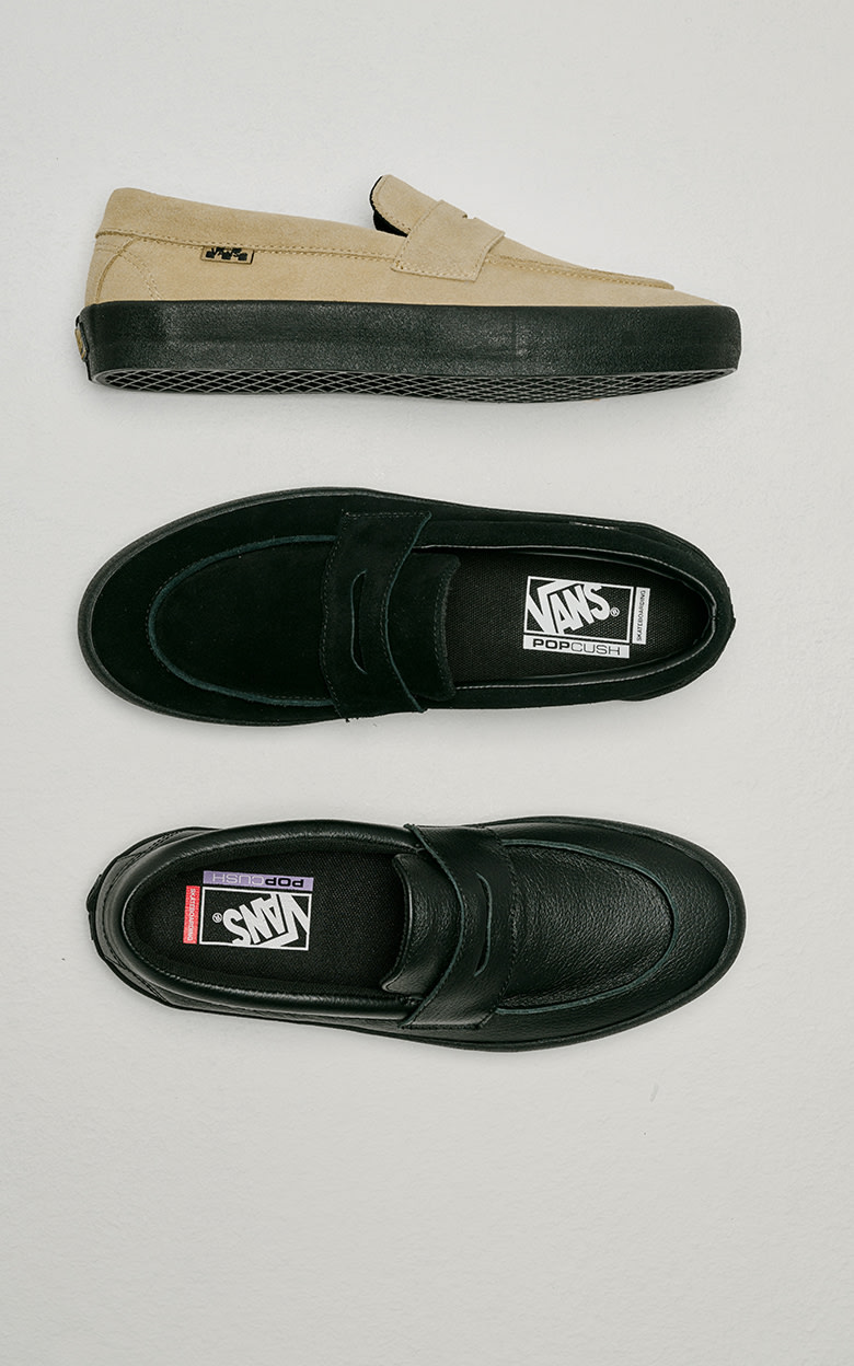 Overhead shot of three Skate Loafers on the floor of a grey photography studio. Top is tan suede, middle is black suede, bottom is black leather.