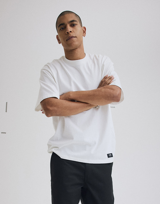 Close-up on a young man posing in a photography studio wearing an egret white Premium Loose Fit T-Shirt.
