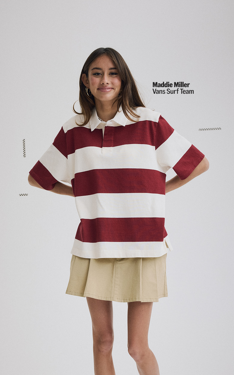 Plan moyen de Maddie Miller portant une minijupe chino Authentic en brun encens et un chandail de rugby bordeaux dans un studio photo gris.