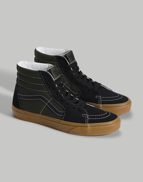 Medium shot of a pair of the Gum Obsidian Fern Green Sk8-Hi upright on the floor of a grey photography studio.