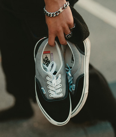 Close-up of a hand holding a pair of the new Skate Era.