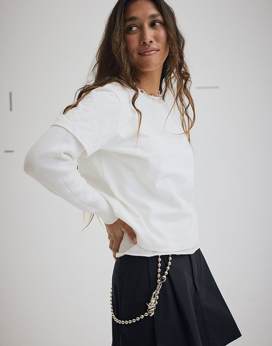 A young woman wearing white t-shirt and black skirt in a photography studio.
