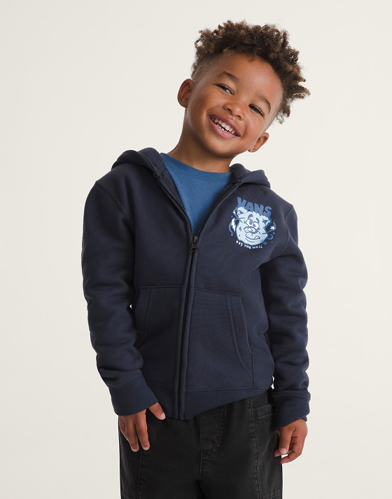 A young boy wearing Parisian night blue Little Kids Dizzy Bear Zip Hoodie in a photography studio.