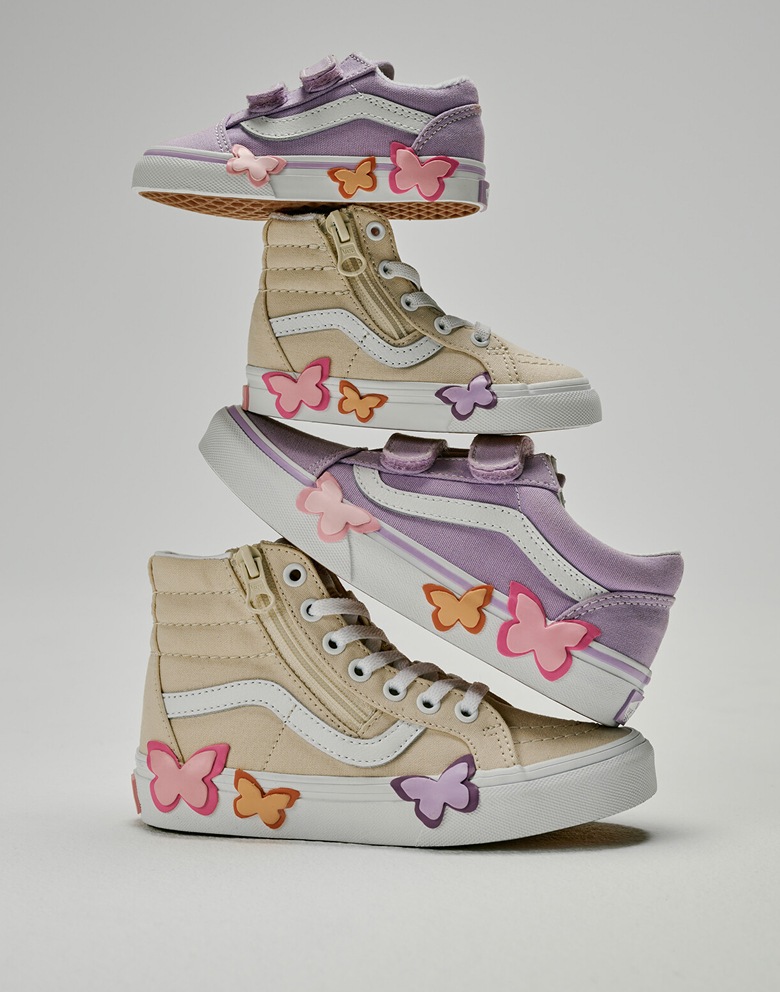 Various kids’ sizes of the Old Skool V and the Sk8-Hi Side Zip with butterfly details stacked on each other in a photography studio.
